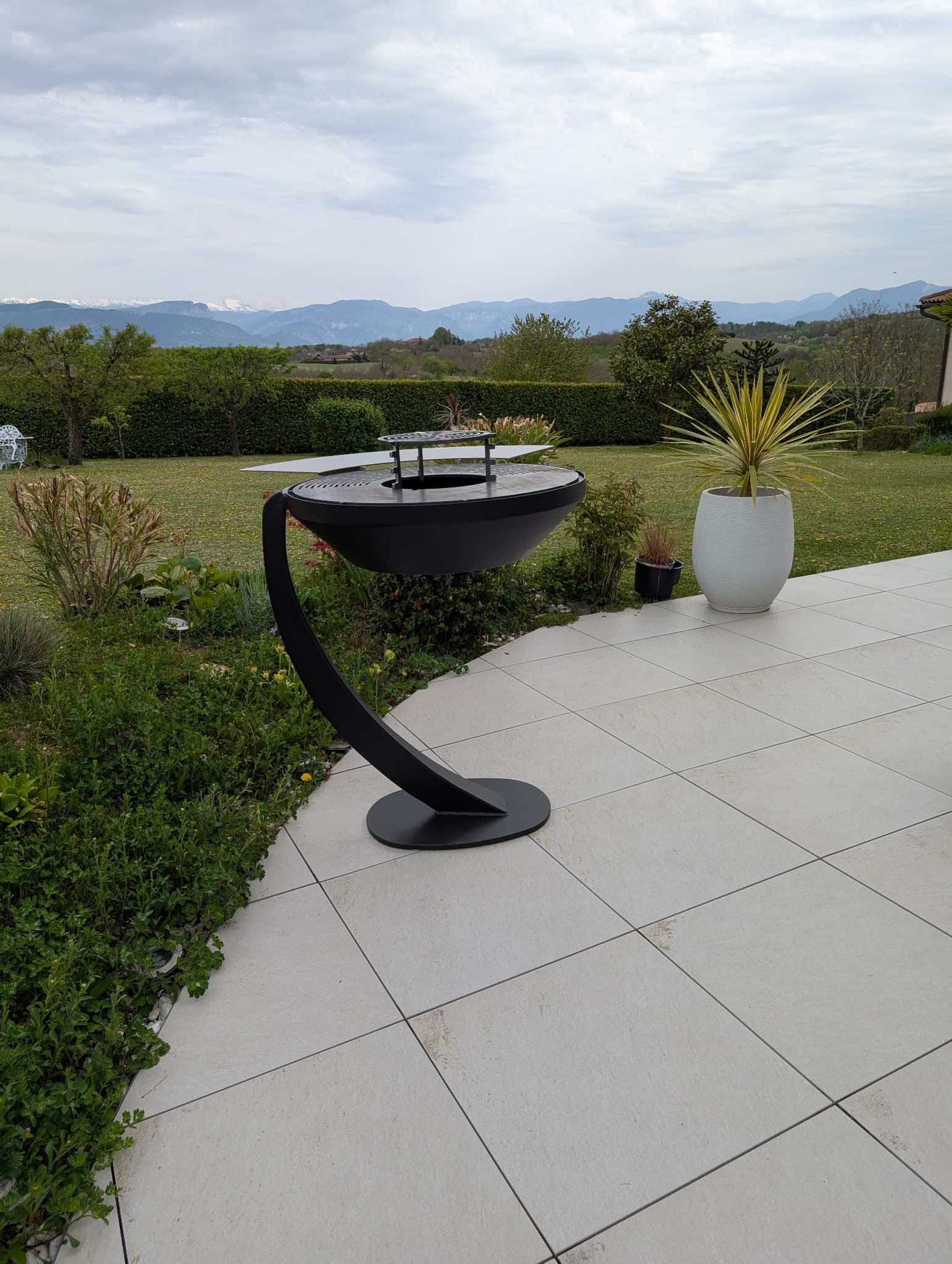 Brasero corten sur une terrasse avec vue dégagée sur les Alpes