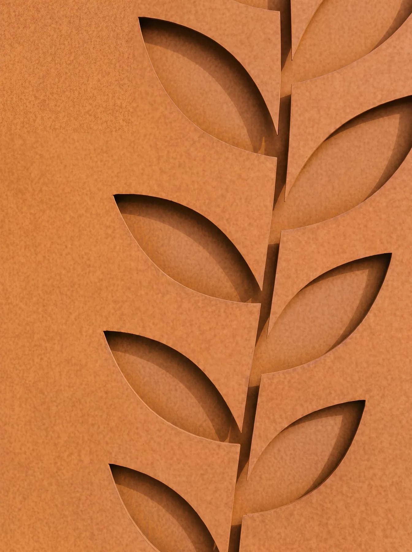 Détail des feuilles découpées au laser sur le flanc en acier corten, paroi intérieure visible en retrait